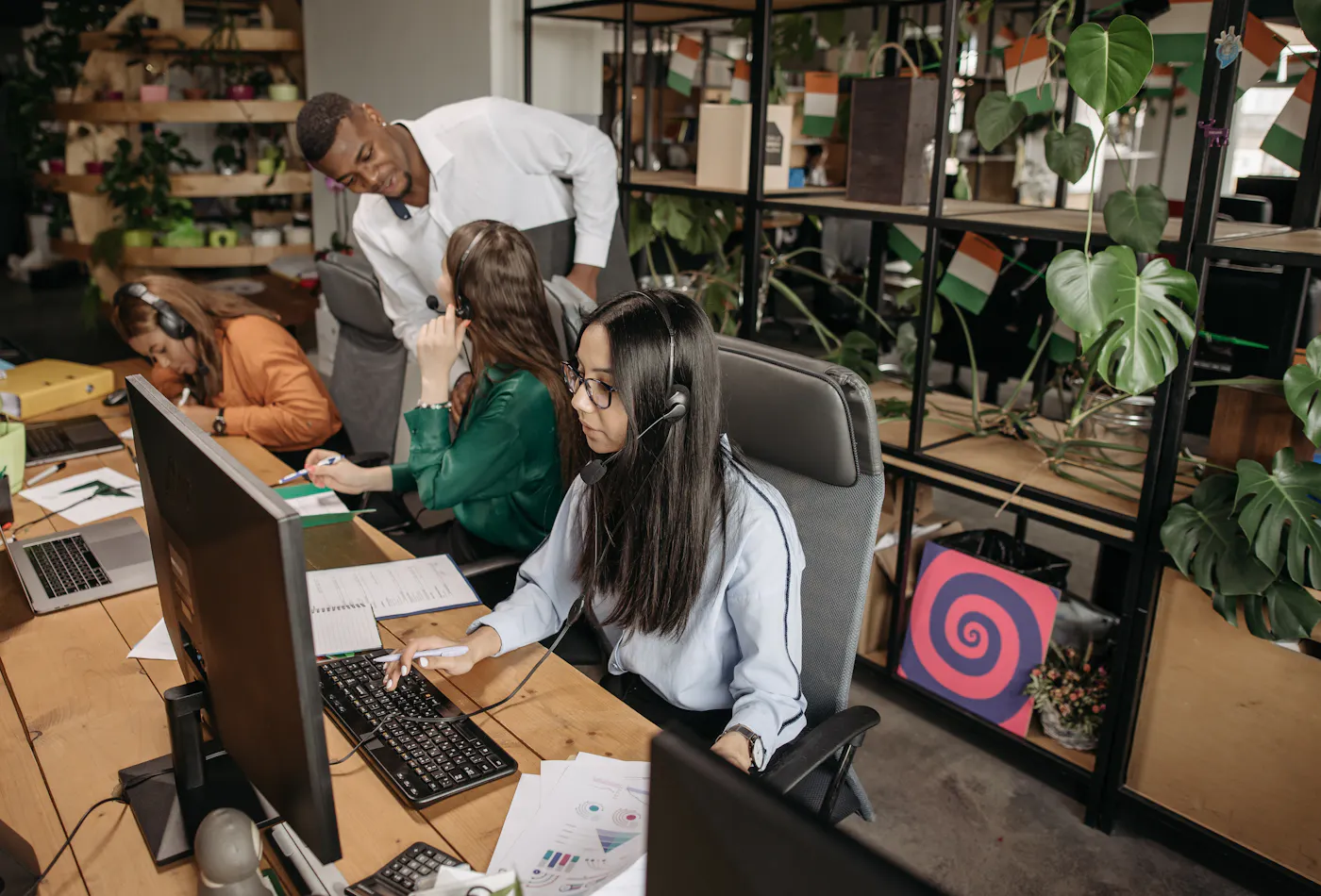 Operations team working at computer desks in a modern service office